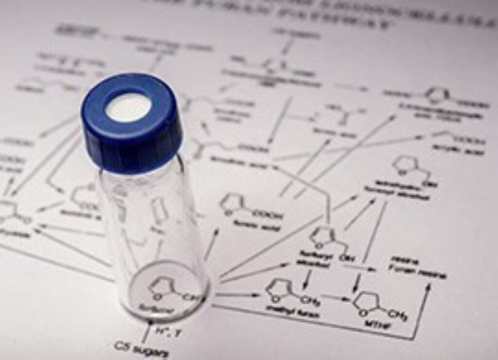 Lab vial on a chemical reaction diagram.