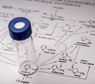 Lab vial on a chemical reaction diagram.