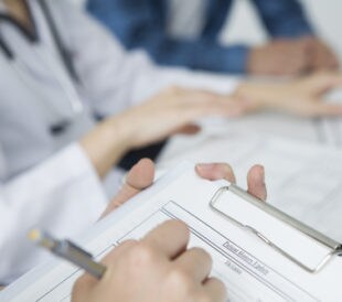 Medical interview being done with a clipboard. Image: Leonardo da/Shutterstock.com
