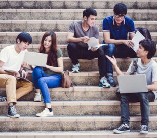 Group of teenagers sitting on stairs and talking. Image: Nonwarit/Shutterstock.com