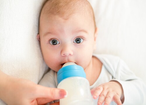 Mother feeding baby with a milk bottle. Image: Oksana Kuzmina/Shutterstock.com.