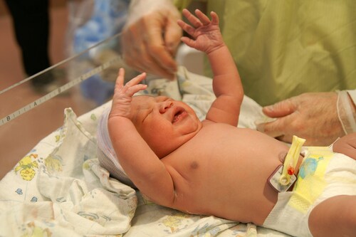 A newborn African-American girl crying on an examination table. Image: Damon Yancy/Shutterstock.com.