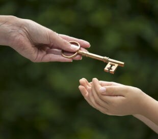 Mother handing key to daughter. Image: eelnosiva/Shutterstock.com.