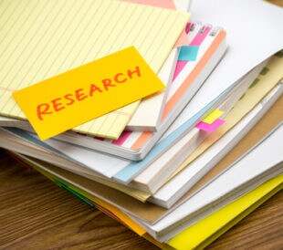 Research; the pile of business documents on the desk. Image: Eiko Tsuchiya/Shutterstock.com.