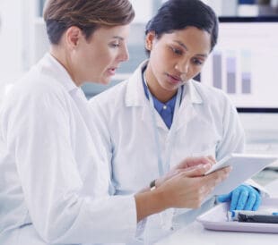 Two female scientists working on a tablet in a laboratory
