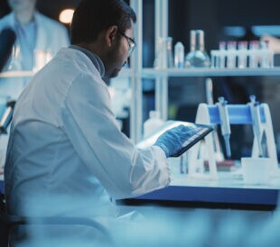 Scientist in a laboratory working on a tablet device.