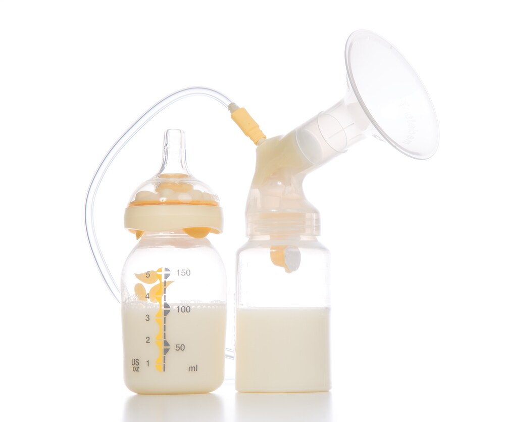 Compact breast pump with breastmilk isolated on a white background