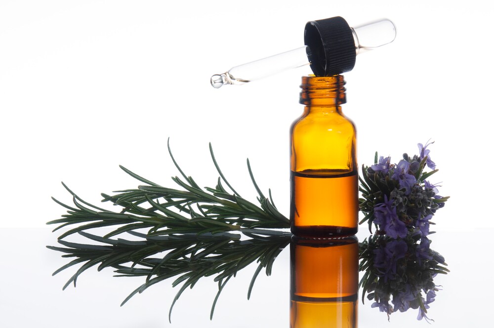 Essential oil in a brown bottle with rosemary