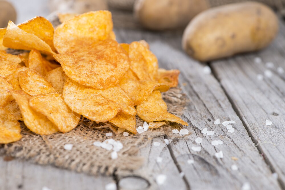 Heap of paprika potato chips on a rustic background