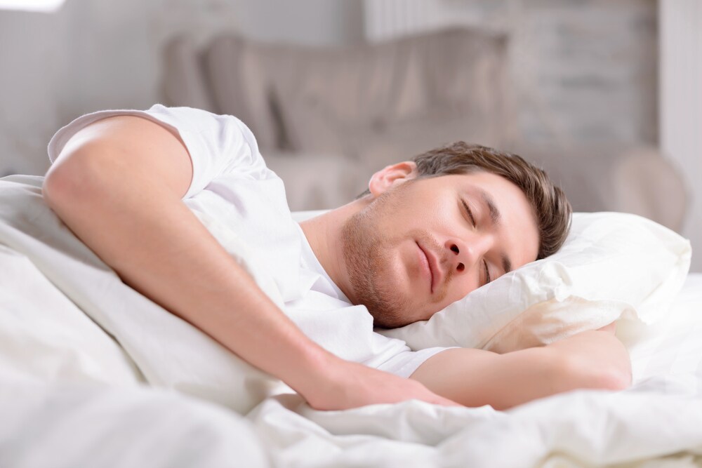 Man sleeping under white covers