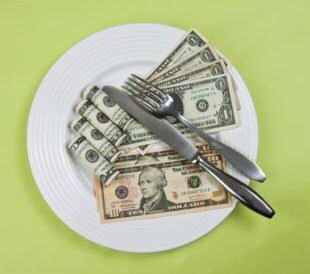 money on plate with fork and knife