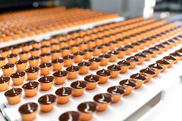 Production of pralines in a factory for the food industry - automatic conveyor belt with chocolate