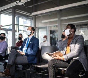 attendees with covid masks at a meeting