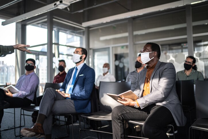 attendees with covid masks at a meeting