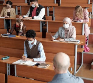 picture of college classroom with students wearing covid masks