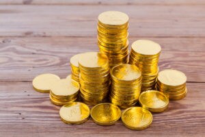Stacked gold coins on a wooden background