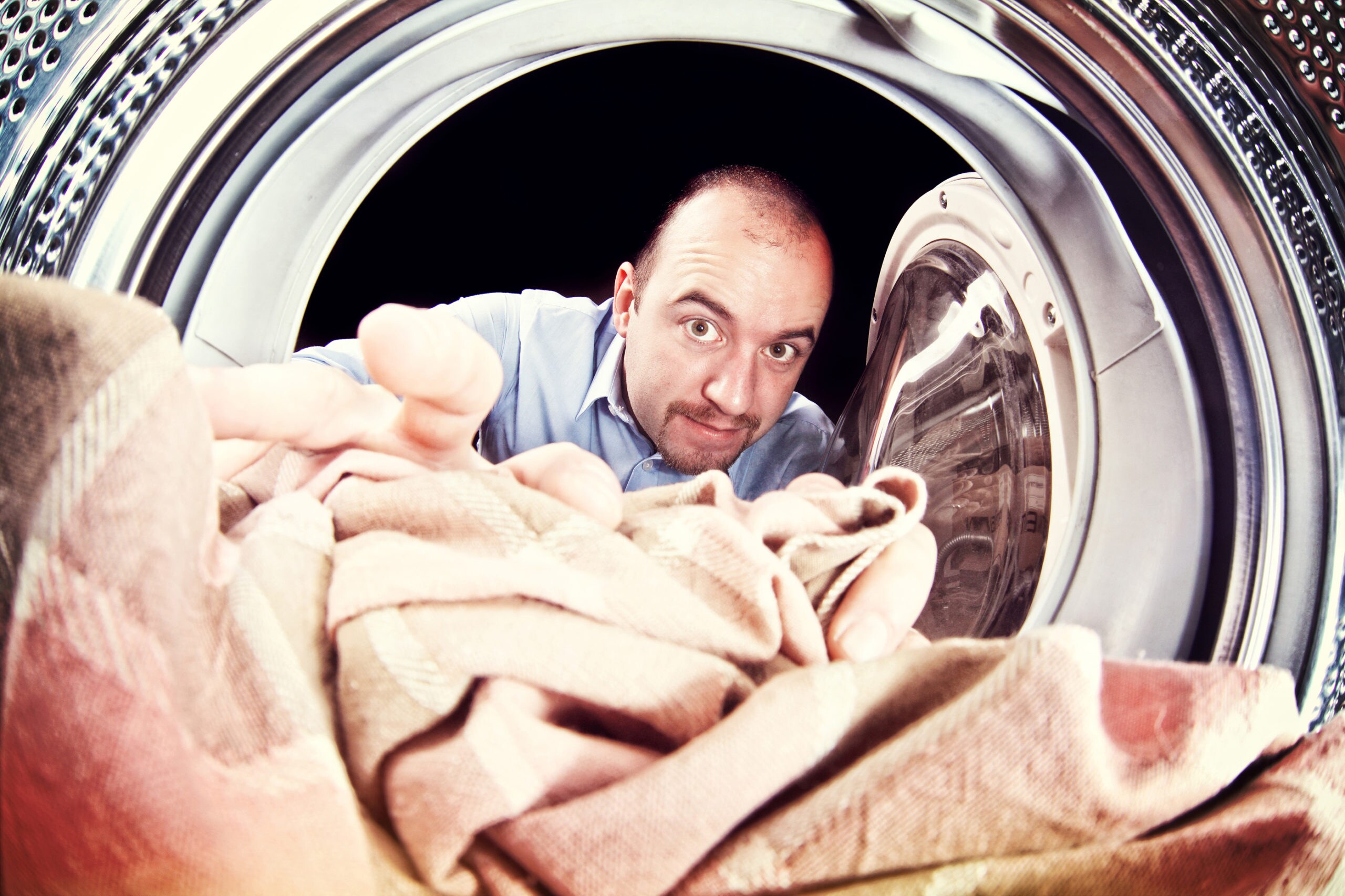 portrait of man view from washing machine inside