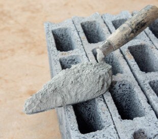 Cement powder or mortar with trowel put on the Concrete brick for construction work.