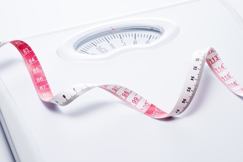 Close-up of a tape measure and bathroom scale. Image: kai keisuke/Shutterstock.com.