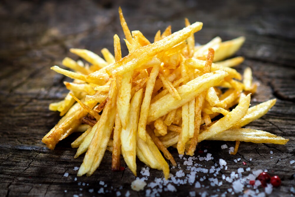 French fries with sea salt on a dark wooden background