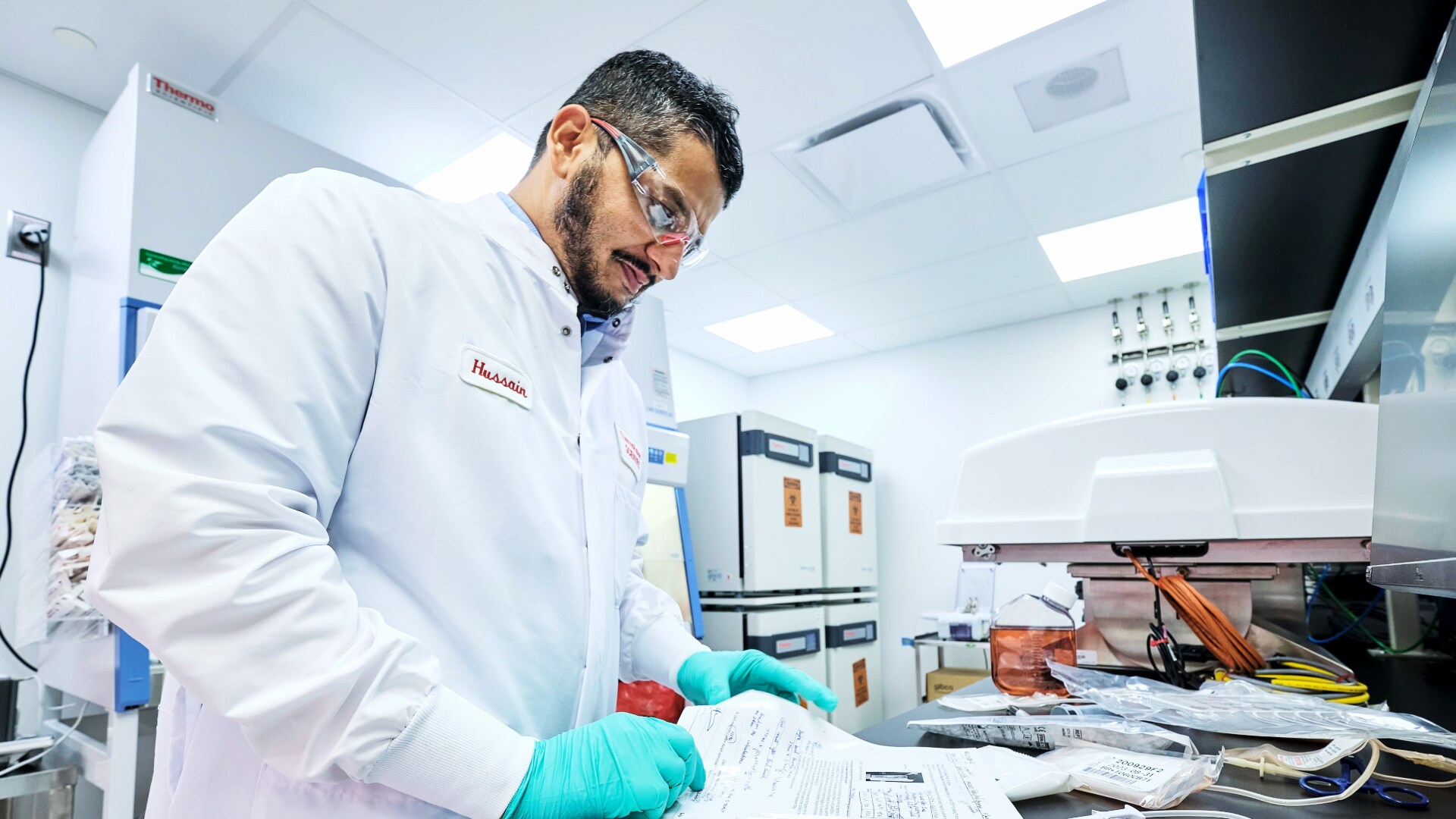 Researcher studying paper on a lab bench