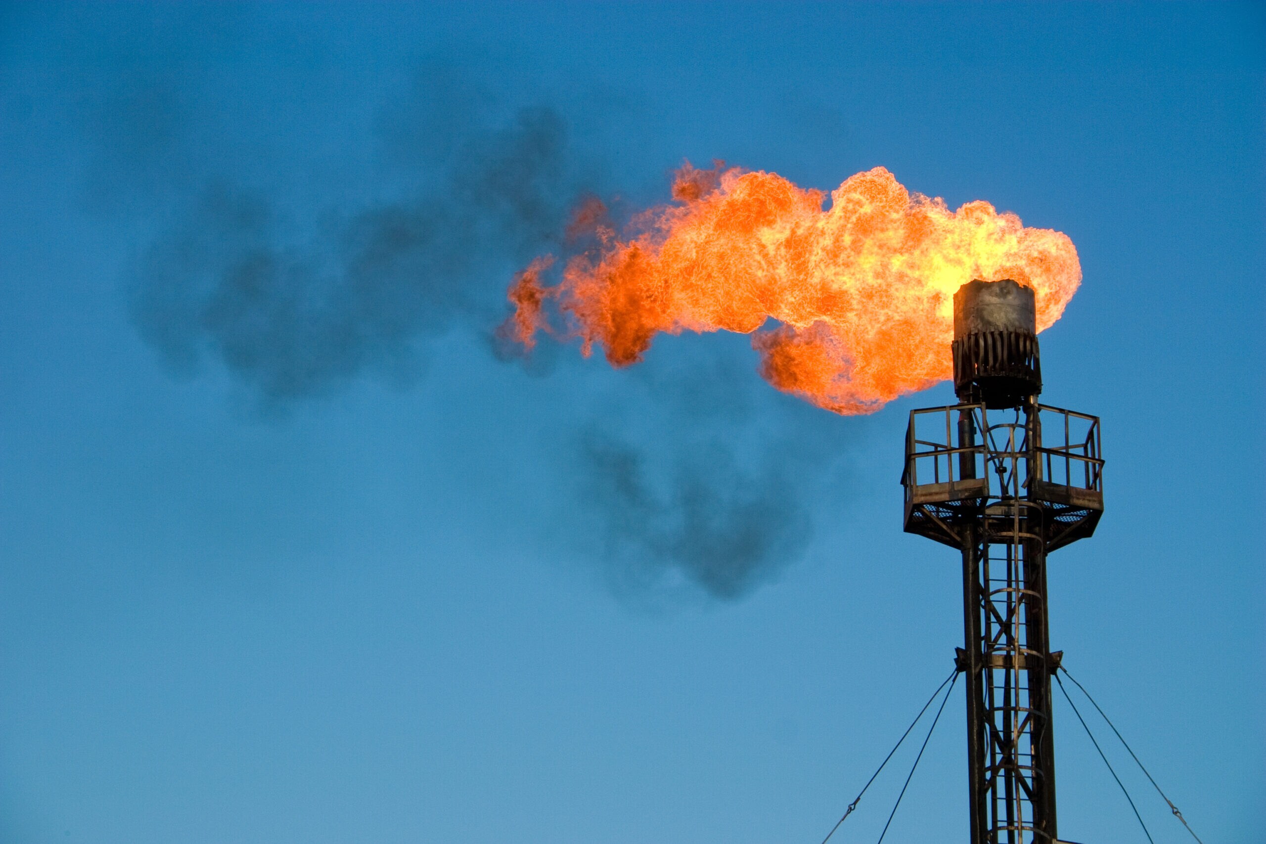 Burning oil flare on a blue skyBurning and smoking oil gas flare