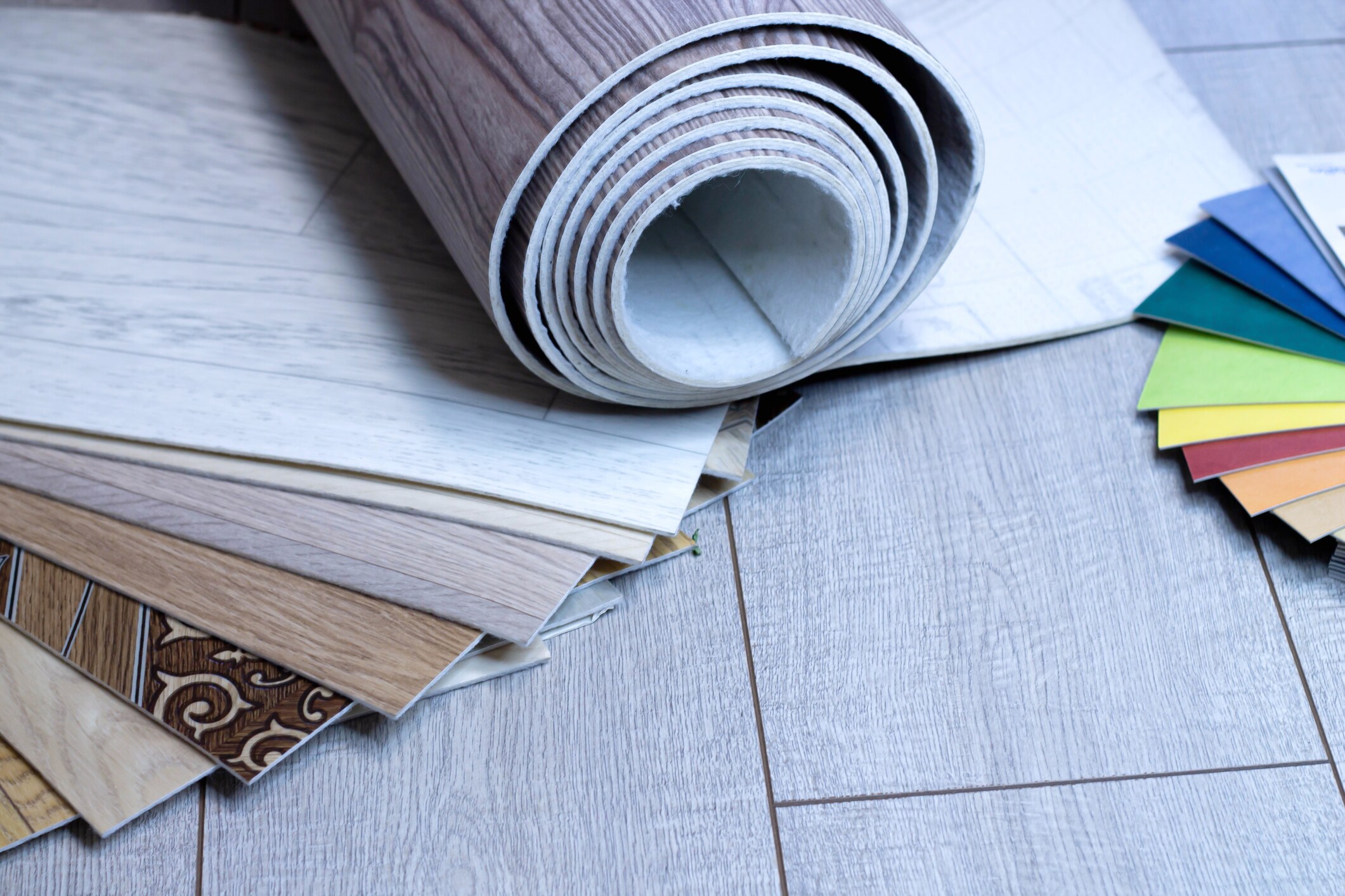 A piece of linoleum for samples. Sliced wood grain linoleum. Multi-colored floor coverings. Measurement and cutting of pvc coating. Roll.