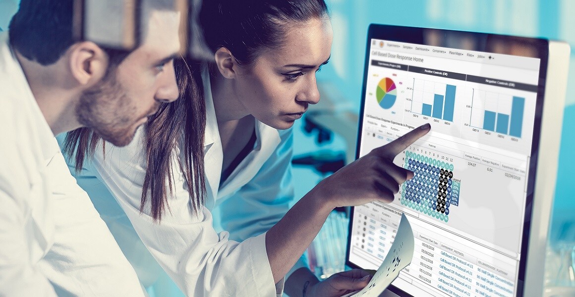 Core_LIMS_laboratory_shot Two scientists looking at Core LIMS software on desktop